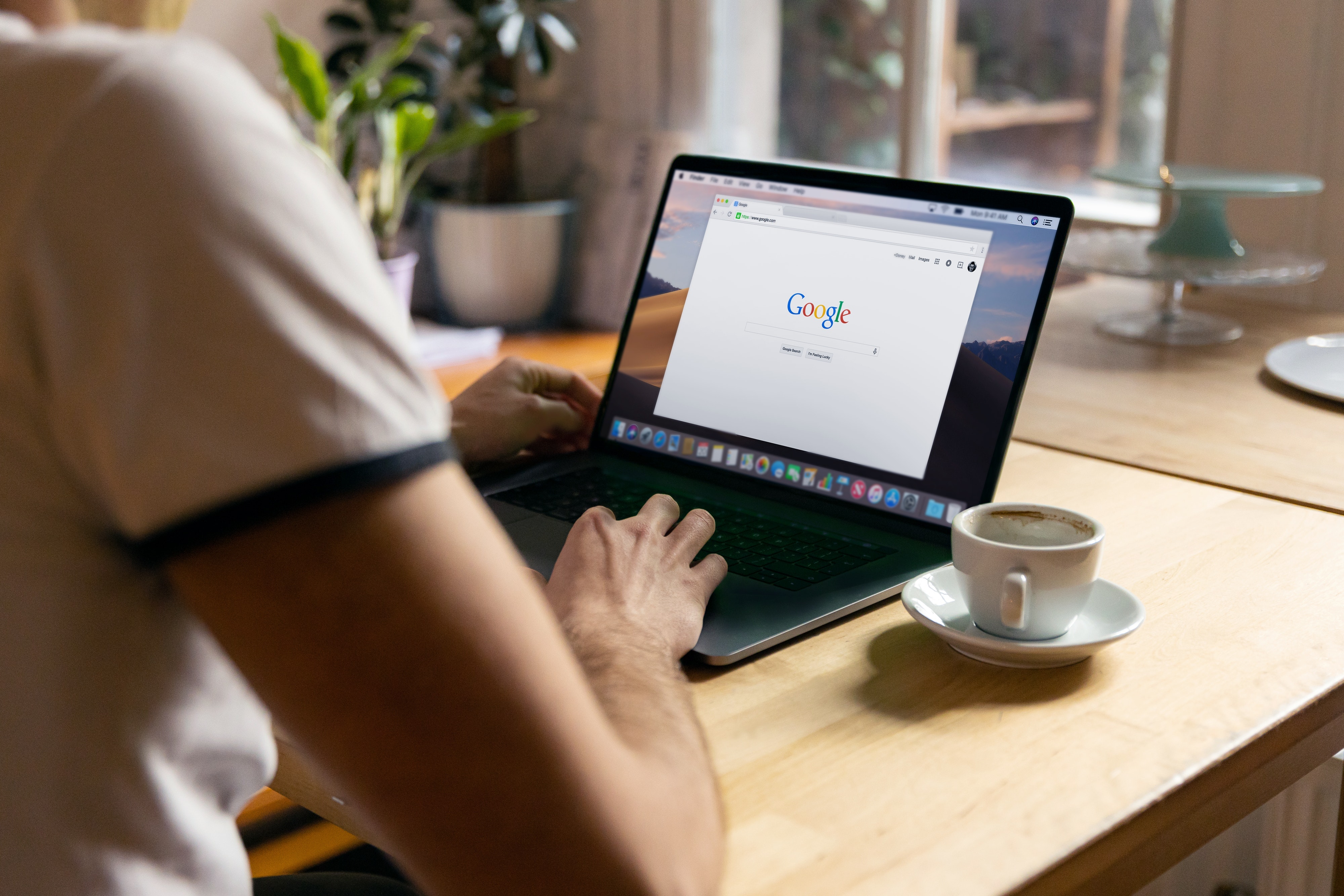 Person googling on a laptop at a cafe