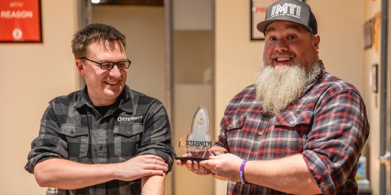 Senior Website Designer and Developer Rob Liberty receiving his 10 year anniversary plaque from Mike Lannen at an Eternity Team Dinner Event.