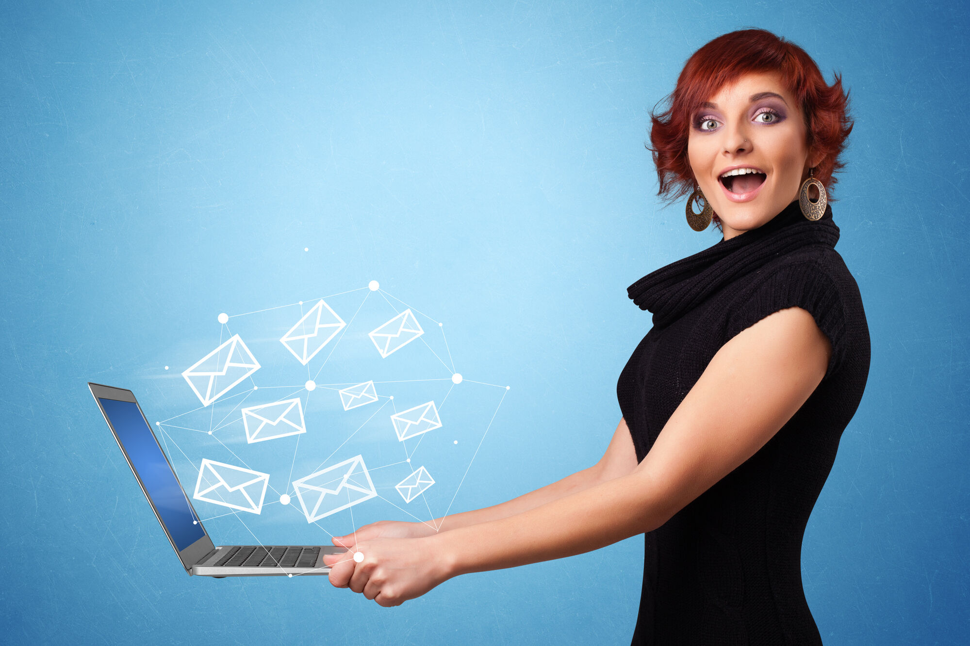 happy woman holding a laptop with email icons floating above it