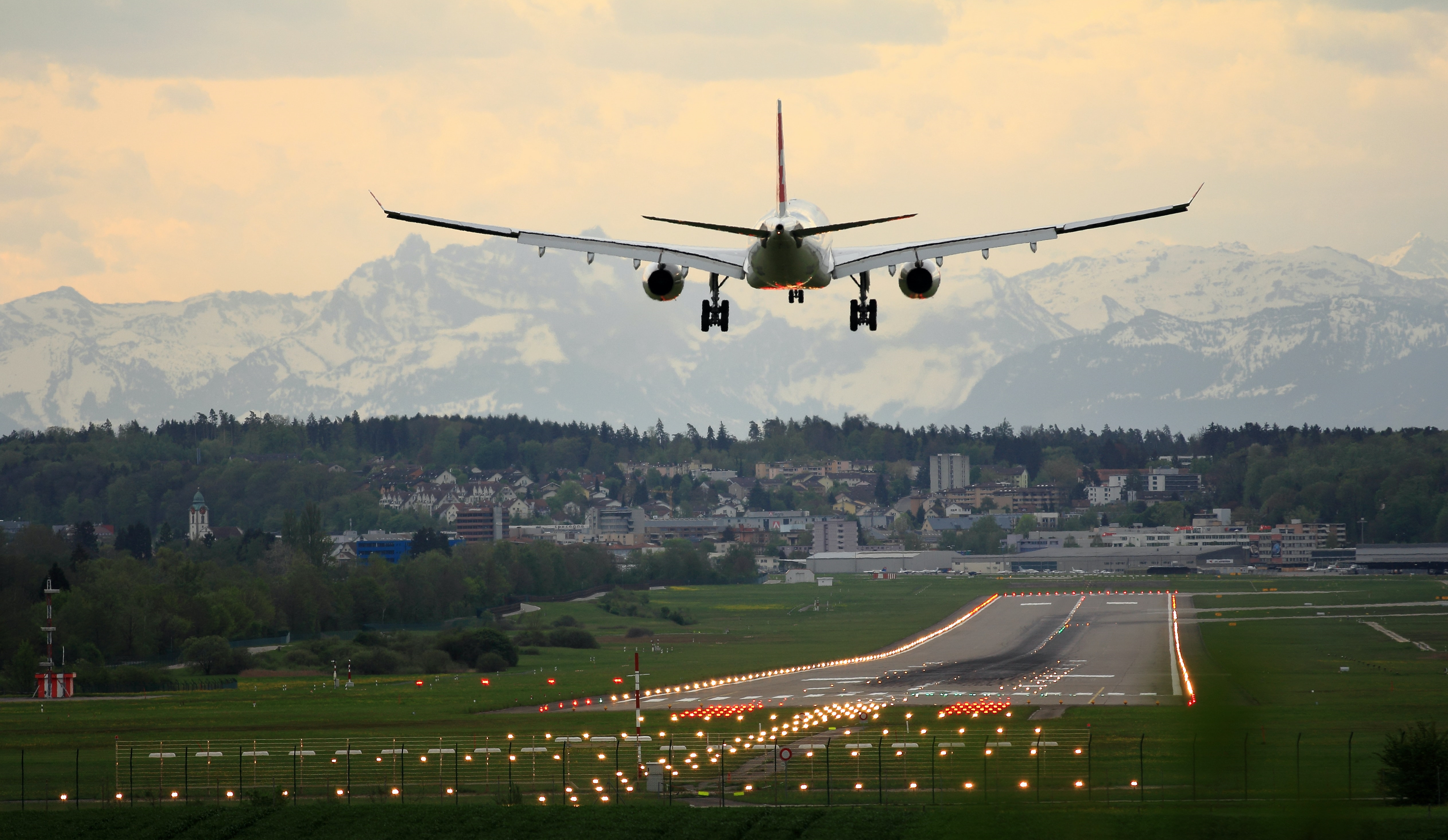 Airplane landing on a runway just outside a city